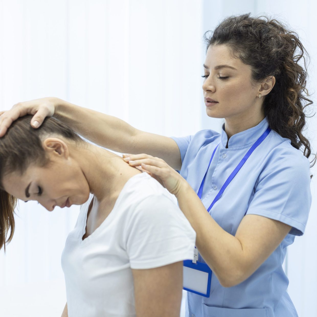 Physiotherapist doing healing treatment on womans neck,Chiropractic adjustment, pain relief concept.office syndrome Physiotherapist doing healing treatment on womans neck,Chiropractic adjustment, pain relief concept.office syndrome